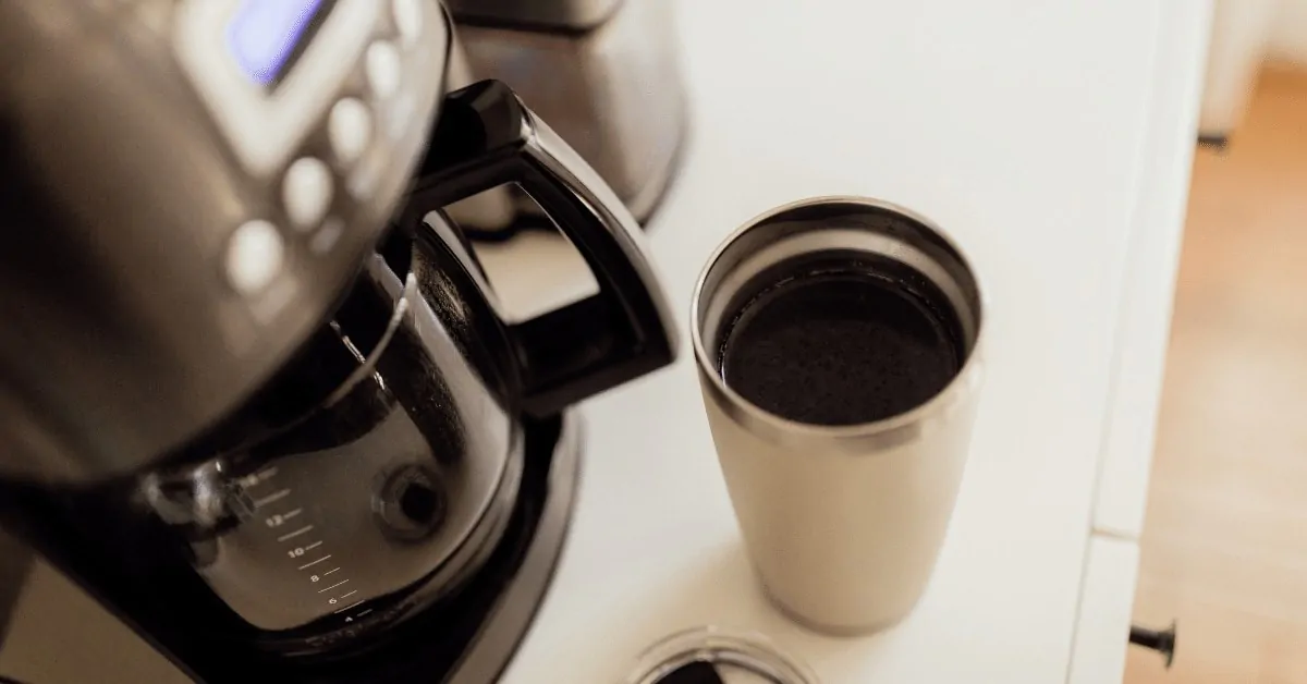 4 cup coffee maker and a cup of coffee