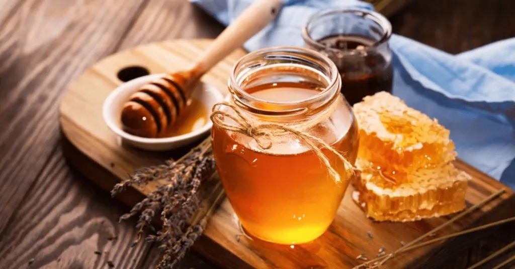 honey and honeycomb with a cup of coffee in the background