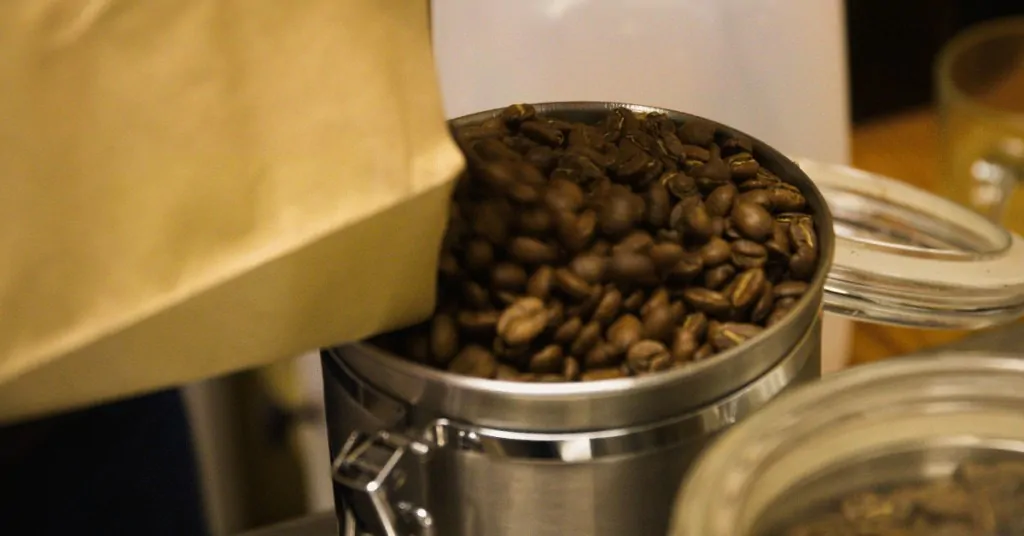 person filling a coffee canister with beans