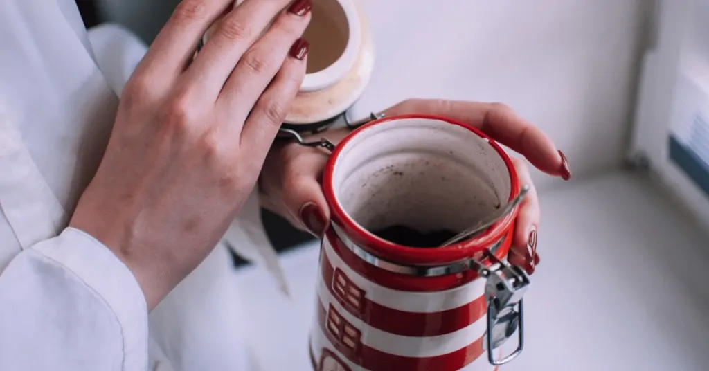 woman holding a ceramic coffee container