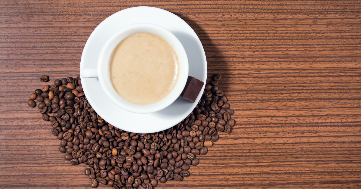 cup of espresso and coffee beans on table