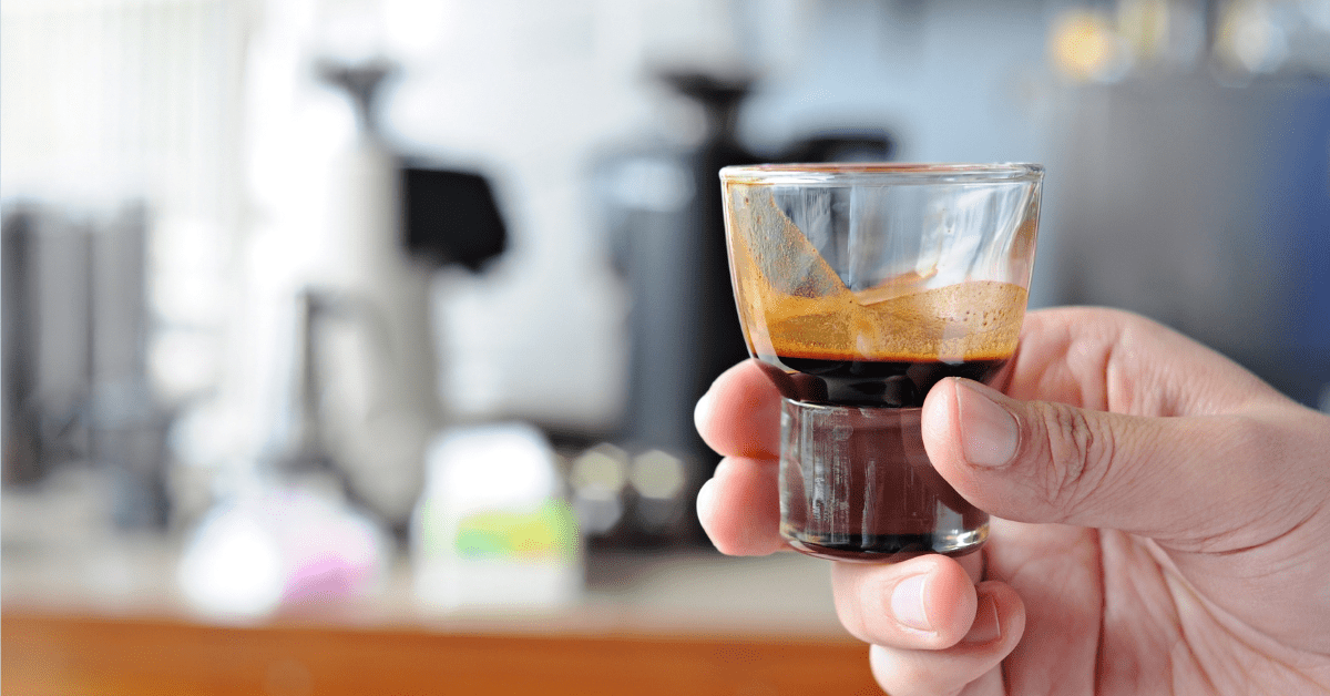 the person holding ristretto in glass