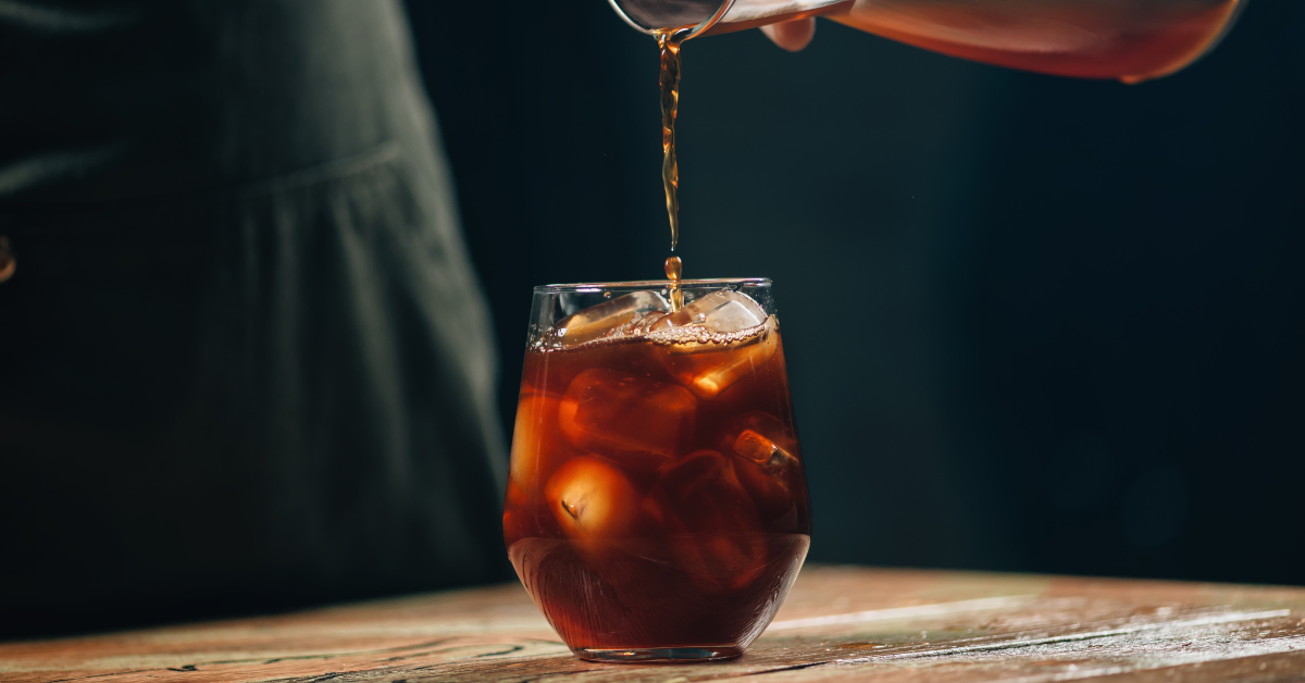 barista pouring coffee in a glass