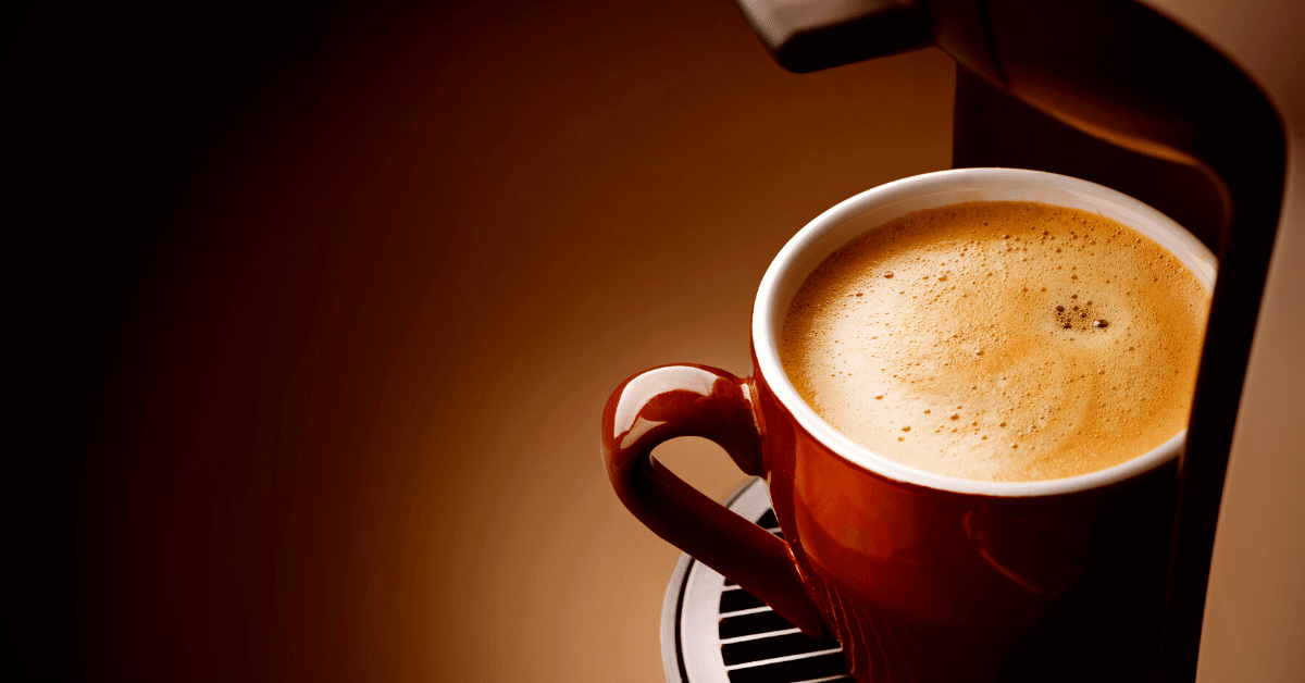 cup of coffee under coffee machine