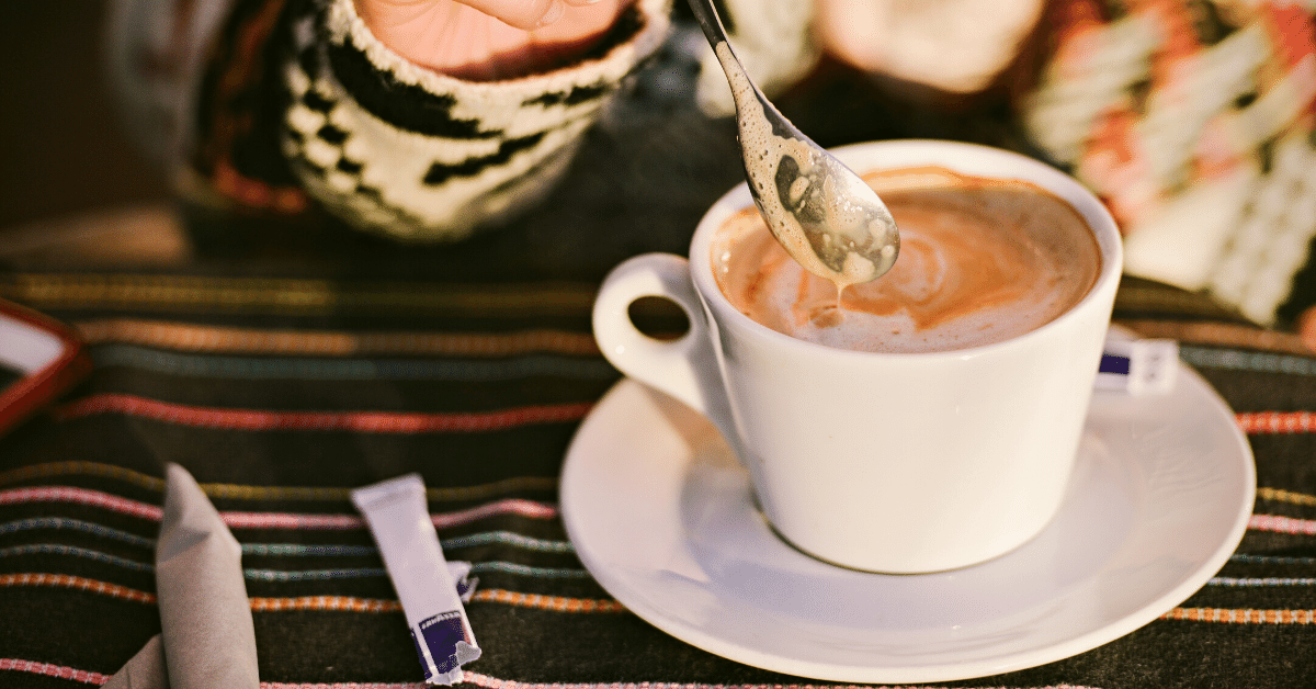 person stirring cappuccino