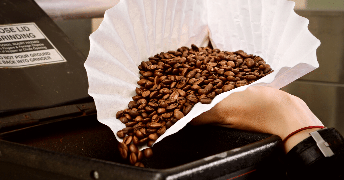 pouring coffee beans into grinder